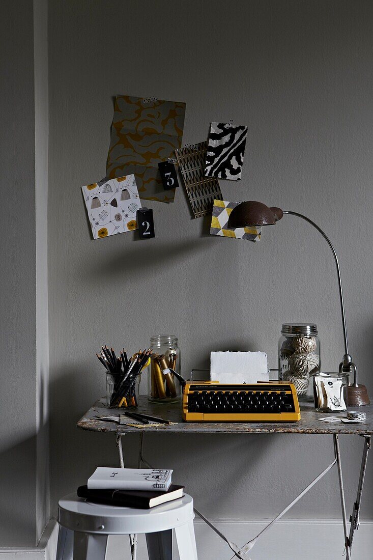 Vintage-Lampe und Moodboard mit Schreibmaschine auf dem Schreibtisch im Home Office