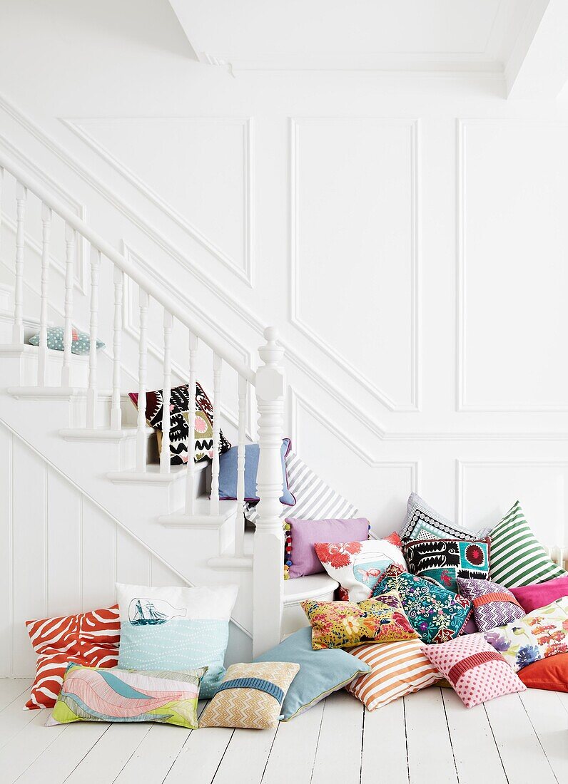 Gemischte Kissen auf weiß gestrichener Treppe in Einfamilienhaus
