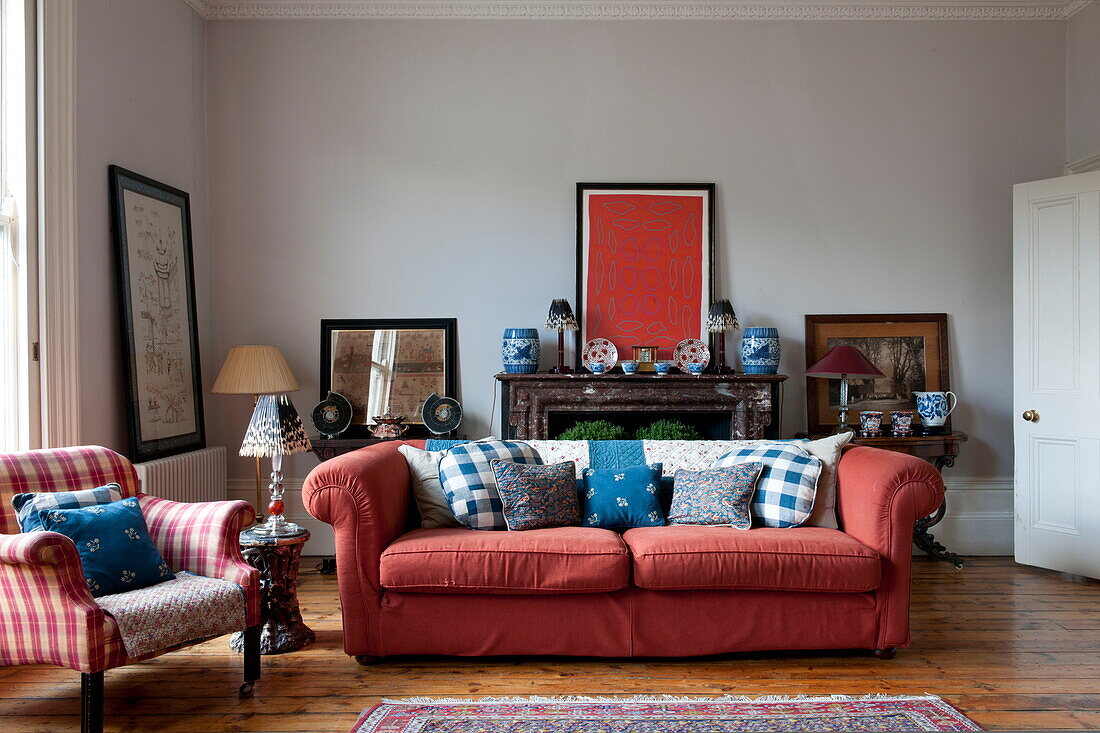 Rotes Sofa und Kunstwerk mit Marmorkamin in einem Haus in Greenwich, London, England, UK