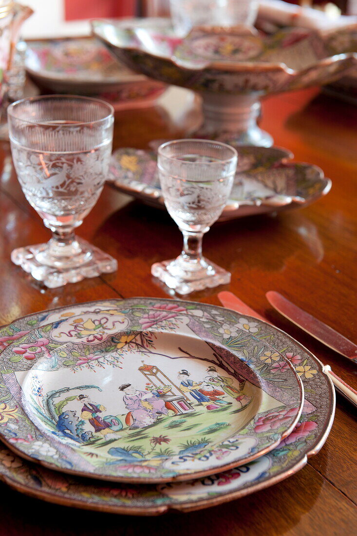 Vintage-Teller und -Gläser auf dem gedeckten Esstisch in einem Haus in Greenwich, London, England, UK