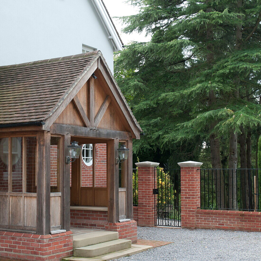 Hölzerne Veranda und Kiefer mit Kiesauffahrt vor einem Haus in Haywards Heath, West Sussex, England, UK