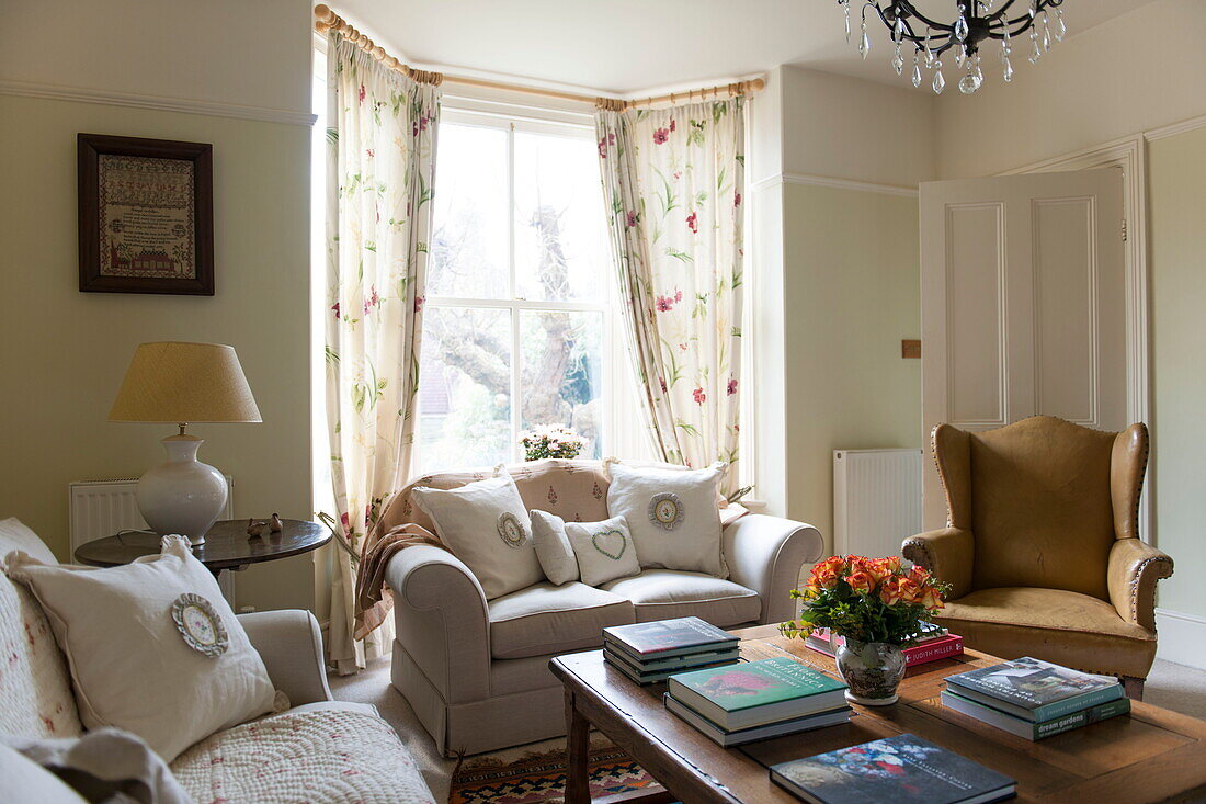 Ledersessel mit cremefarbenen Sofas im Wohnzimmer eines Hauses in Ashford, Kent, England, UK