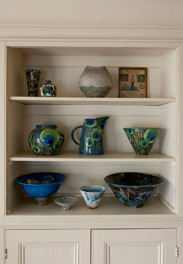 Handbemalte Keramik auf eingebauter Ablage in einem Haus in Ashford, Kent, England, UK