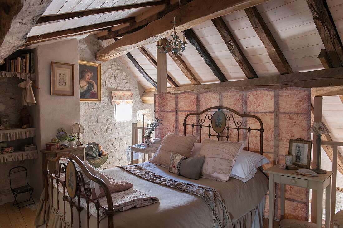 Antikes Bett im Dachgeschoss eines Bauernhauses mit Balken, Dordogne, Frankreich