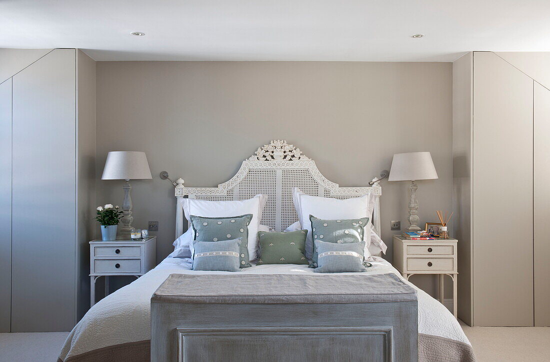 Double bed with wicker headboard in room with concealed storage Battersea home,  London,  England,  UK