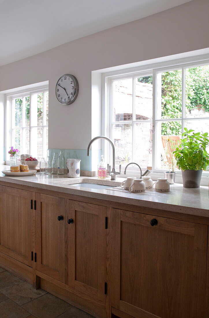 Uncurtained windows in wooden fitted kitchen of Kingston home,  East Sussex,  England,  UK