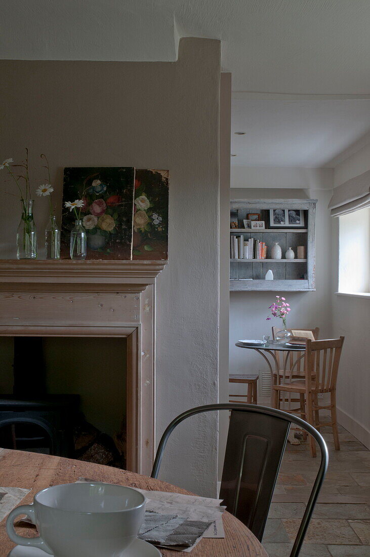 Kunstwerk und Schnittblumen in der Küche im Esszimmer des Hauses in Kingston, East Sussex, England, UK