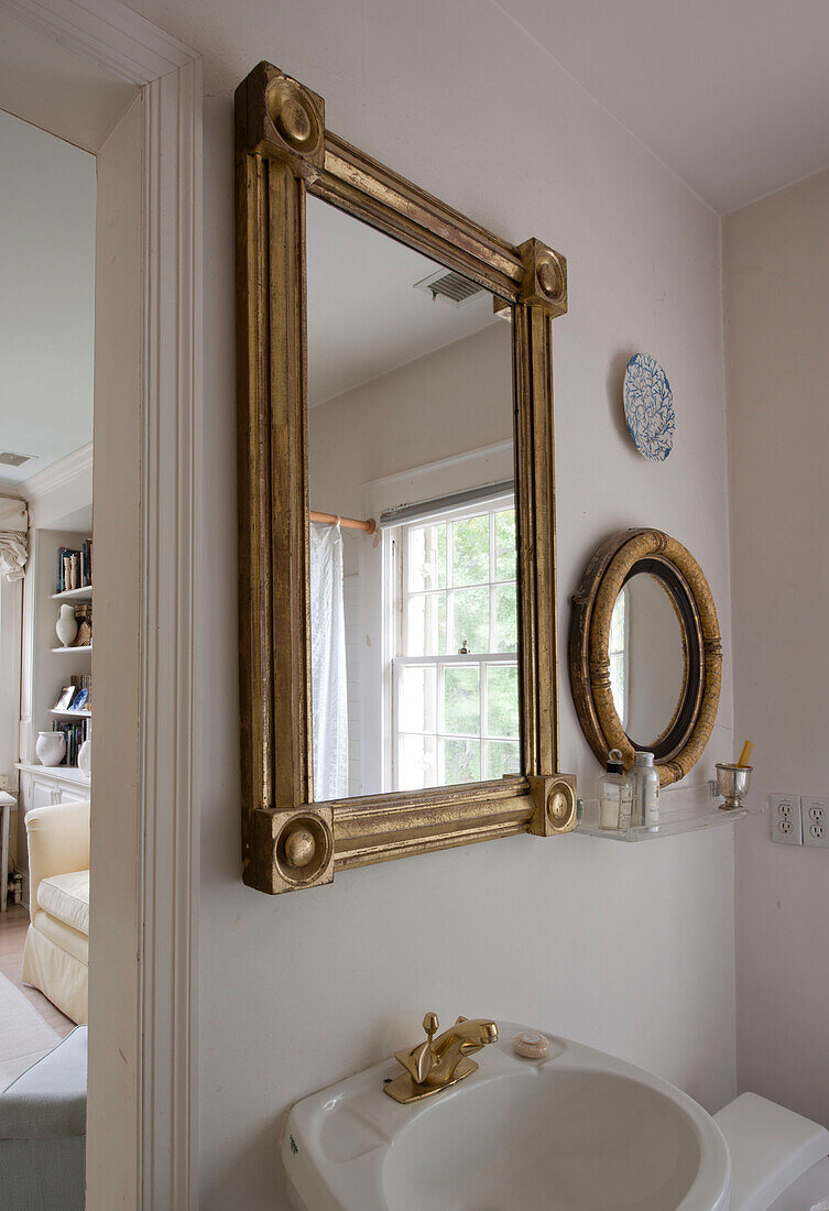 Gilt framed mirrors above wash basin in Washington DC home,  USA