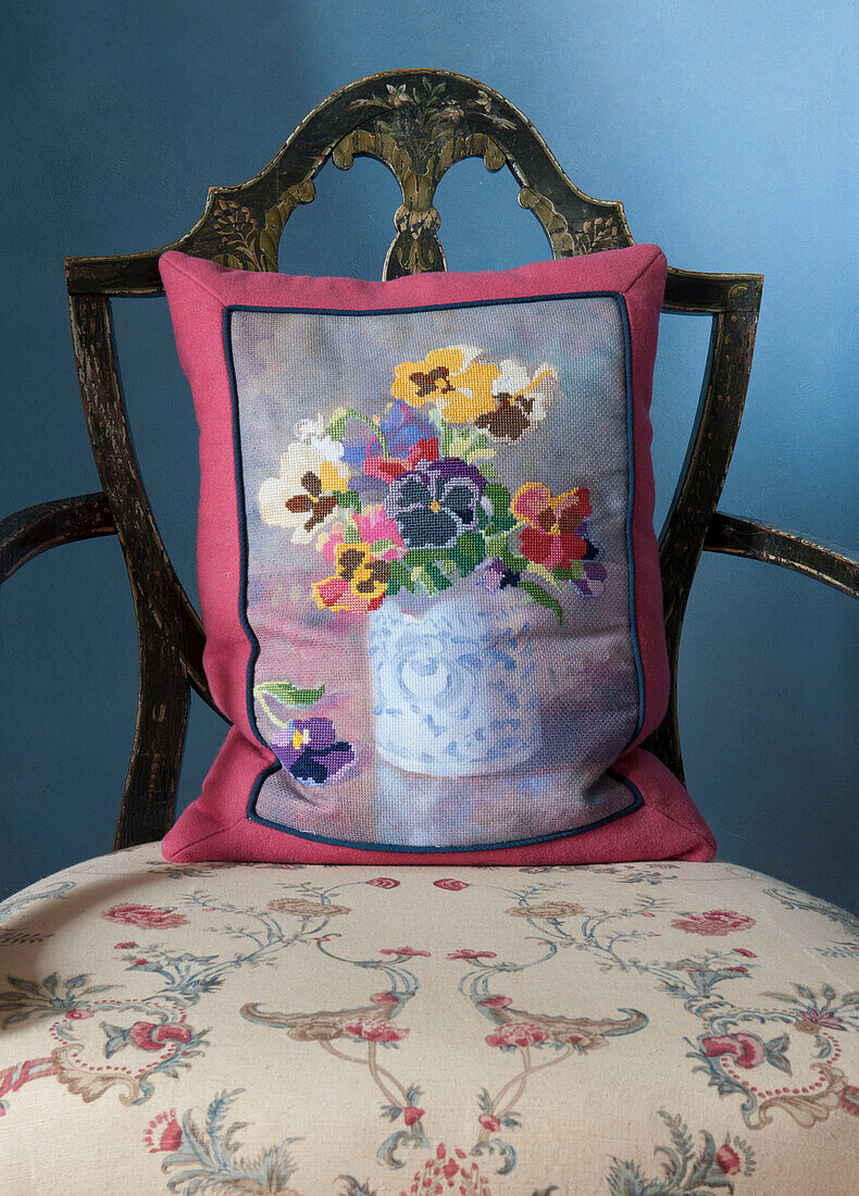 Tapestry cushion on antique floral armchair in Tiverton country home,  Devon,  England,  UK