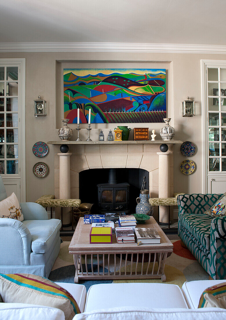 Bright artwork above fireplace in living room of Tiverton country home,  Devon,  England,  UK