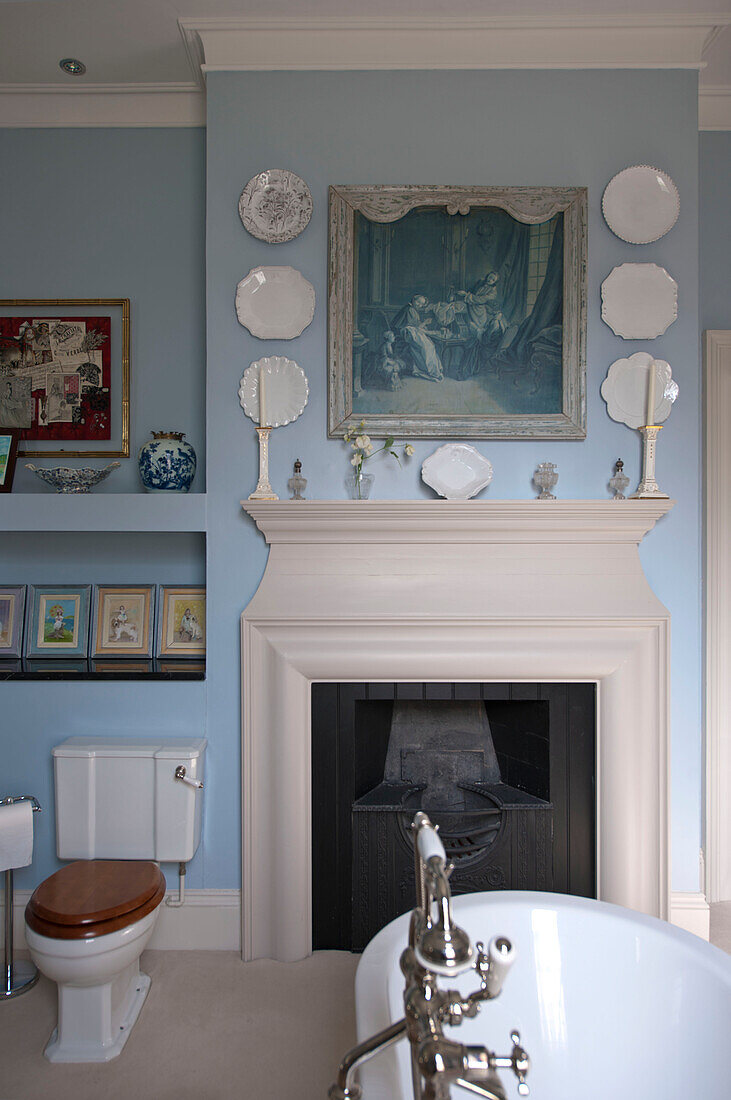 Decorative plates above fireplace in bathroom of Tiverton country home,  Devon,  England,  UK