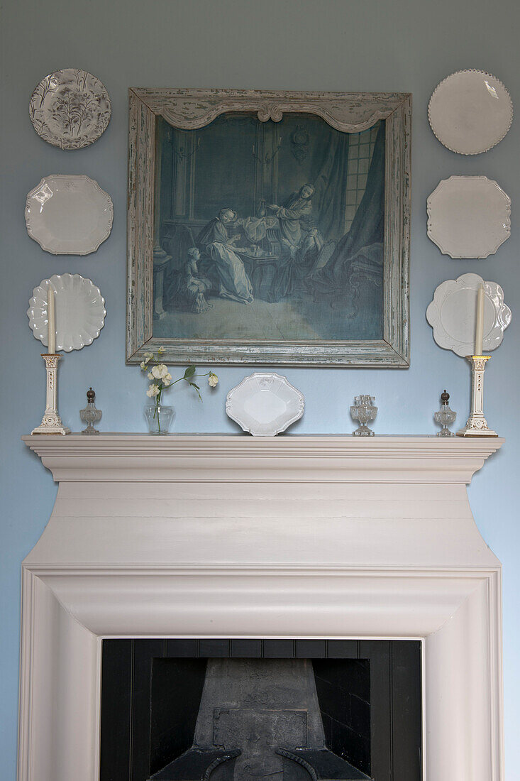 Decorative plates and historic artwork above fireplace in Tiverton country home,  Devon,  England,  UK