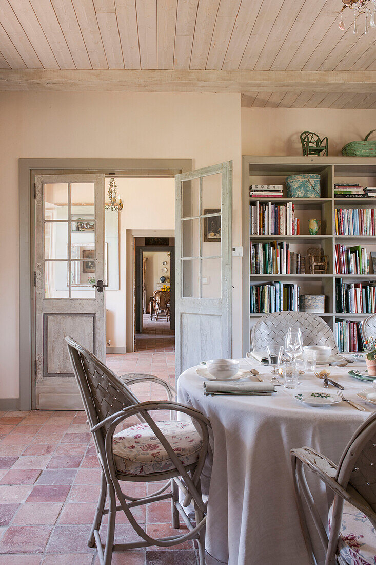 Bücherregal und Esstisch mit Terrakotta-Boden im Landhaus in der Dordogne in Perigueux, Frankreich