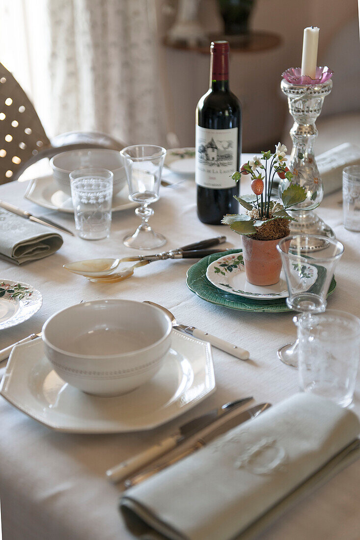 Rotwein mit weißem Geschirr auf dem gedeckten Tisch im Landhaus in der Dordogne in Perigueux Frankreich