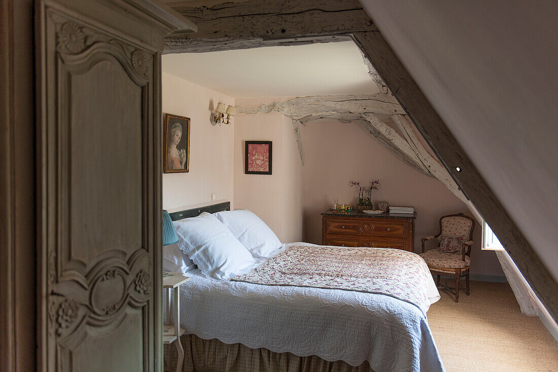 Blick durch die geschnitzte Tür zum Doppelbett im Landhaus in der Dordogne Perigueux Frankreich