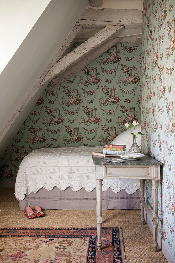 Einzelbett im holzgerahmten und tapezierten Schlafzimmer des Ferienhauses in der Dordogne in Perigueux, Frankreich