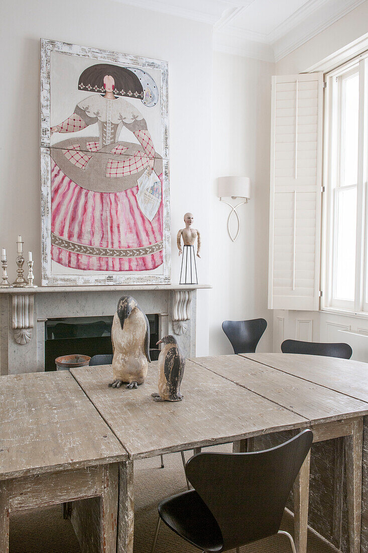 Penguin ornaments on wooden table with artwork of lady in crinoline dress  South Kensington townhouse  London  UK