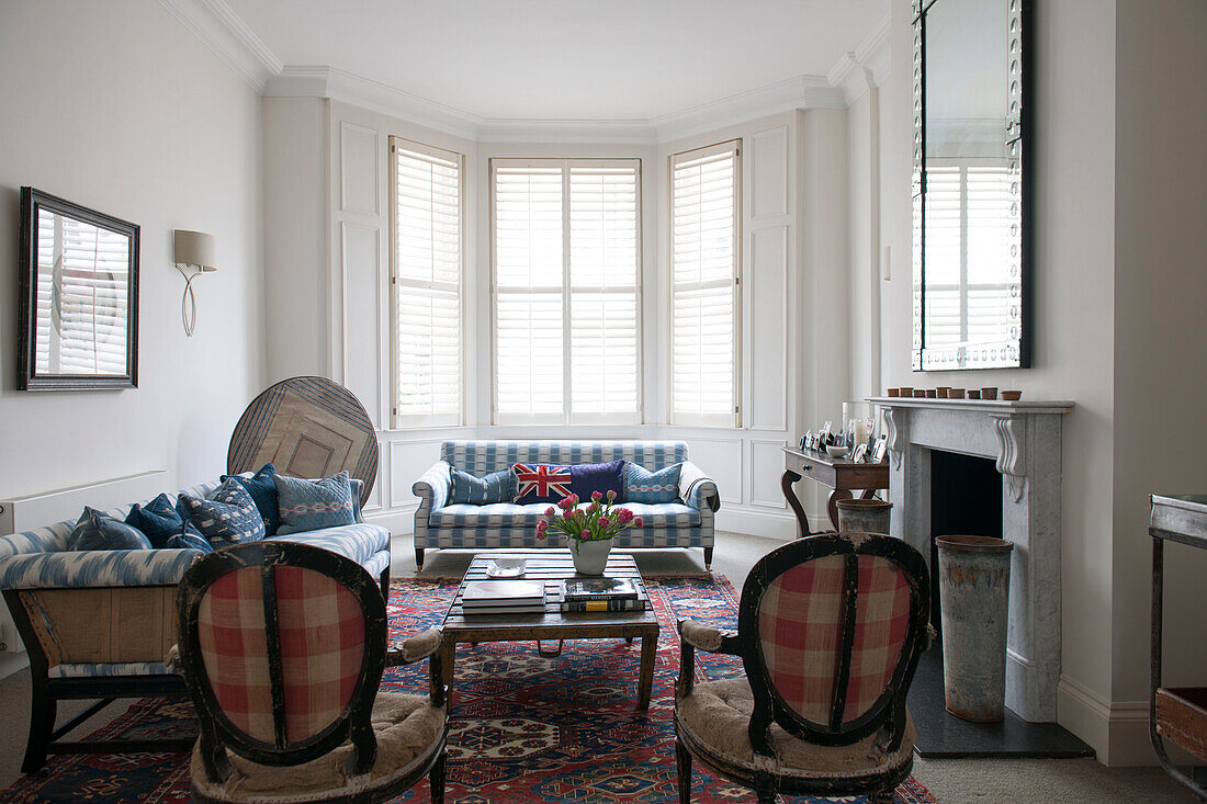 Paar karierte Vintage-Stühle im Wohnzimmer mit Erkerfenster in einem Stadthaus in South Kensington, London UK