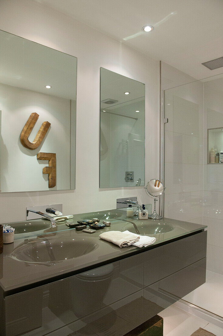 Buchstaben 'F' und 'U' spiegeln sich über Doppelwaschbecken im Badezimmer von South Kensington London UK