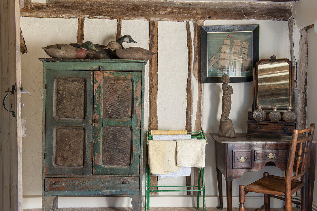 Hölzerne Enten auf verwittertem Beistellschrank mit antikem Frisiertisch und Stuhl in Ashford Bauernhaus Kent UK