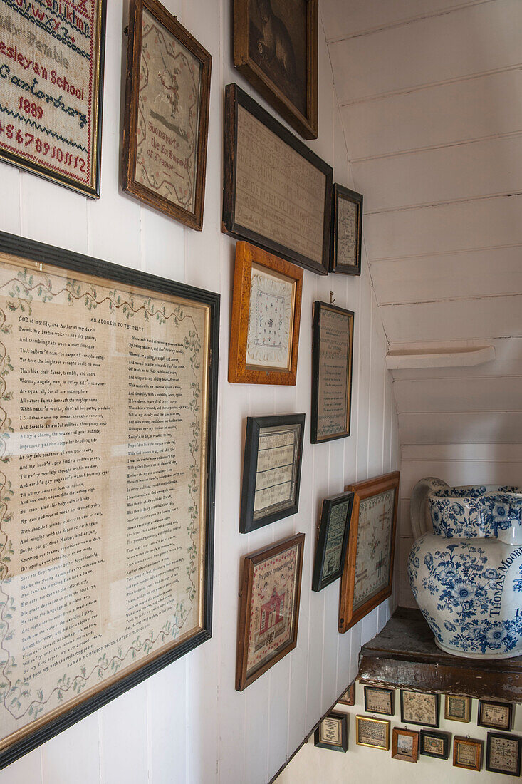 Framed vintage texts and needlepoint in panelled Ashford cottage  Kent  UK