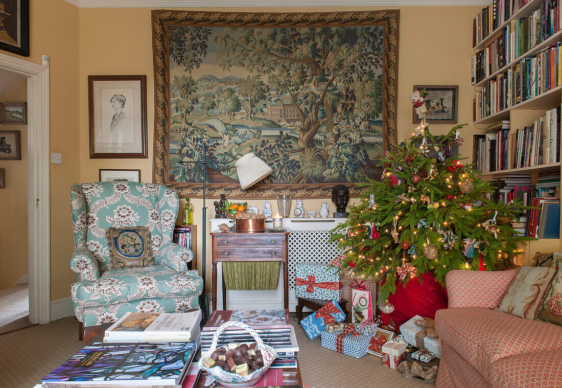 Geschenke unter dem Weihnachtsbaum mit Wandteppich im Londoner Wohnzimmer England UK