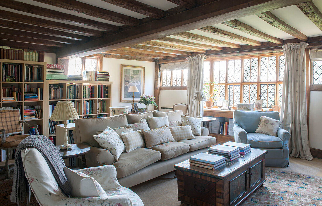 Bücherregale und Sitzgelegenheiten unter der Balkendecke im Wohnzimmer von High Halden mit Bleiglasfenstern, Kent, England, Vereinigtes Königreich