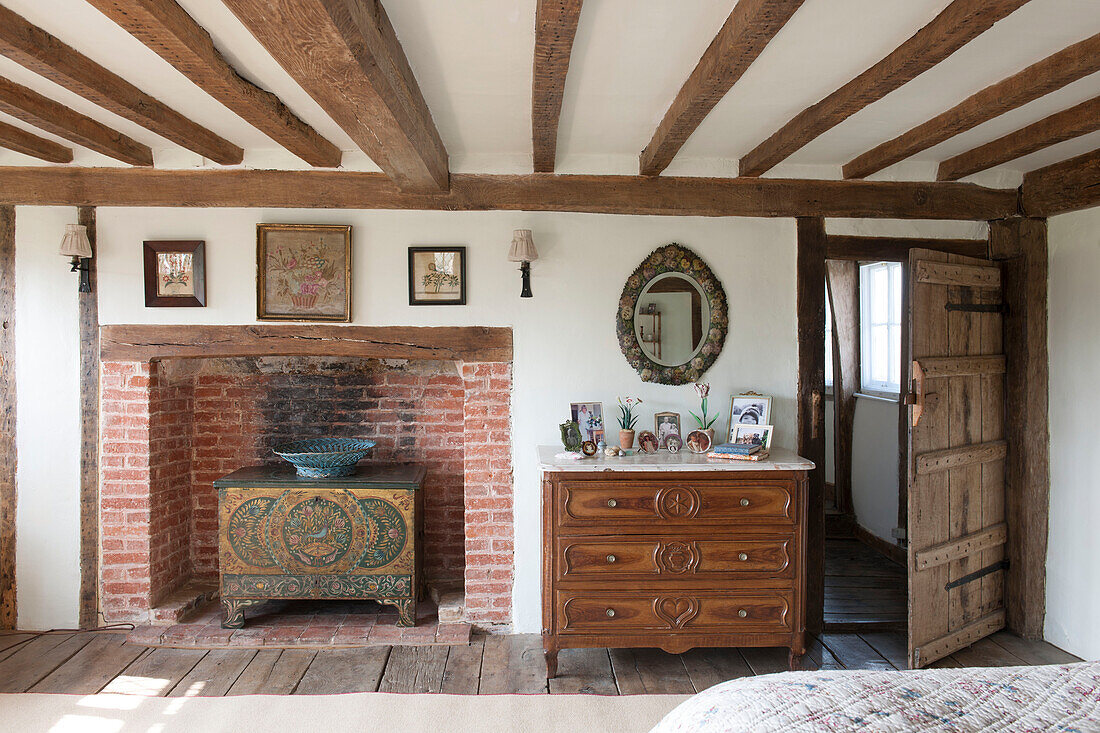 Holzkommode und eingebauter gemauerter Kamin in High Halden cottage mit Balken, Kent, England, Vereinigtes Königreich