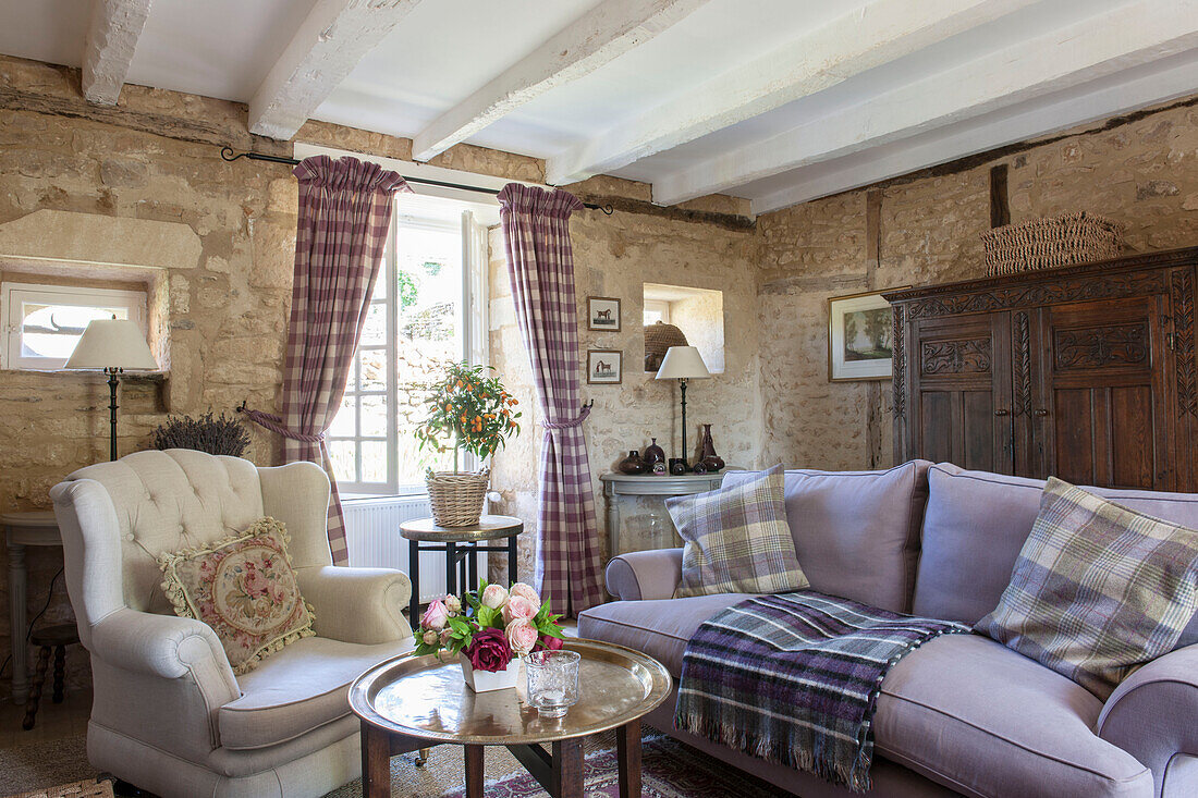 Geknöpfter Sessel und fliederfarbenes Sofa in offenem Stein im Wohnzimmer Dordogne Perigueux Frankreich