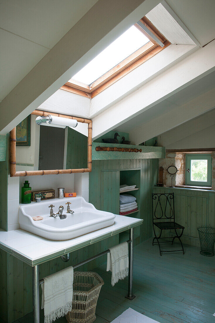 Oberlichtfenster über dem Waschbecken im getäfelten Badezimmer eines Bauernhauses in Lotte et Garonne, Frankreich