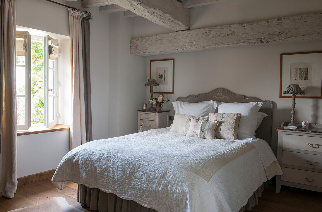 Handmade cushions on double bed at window in beamed Dordogne farmhouse  Perigueux  France
