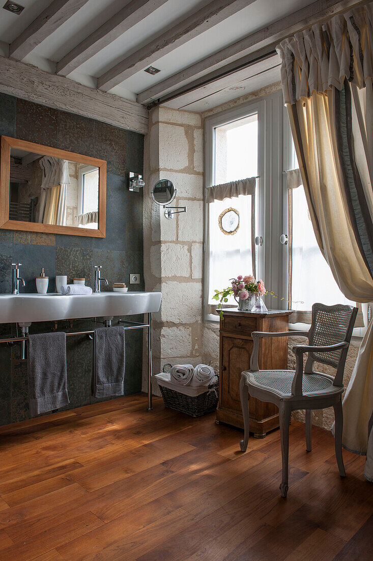 Korbsessel mit Doppelwaschbecken im Badezimmer eines Bauernhauses in der Dordogne in Perigueux Frankreich