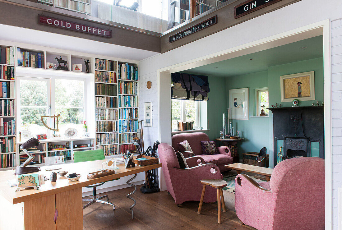 Bücherregale im Wohnzimmer mit doppelter Höhe in einem renovierten Ferienhaus in Norfolk, England UK