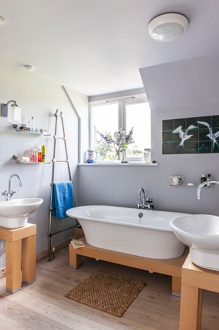 Lilac bathroom with freestanding bath and sinks in Norfolk coastguards cottage  England  UK