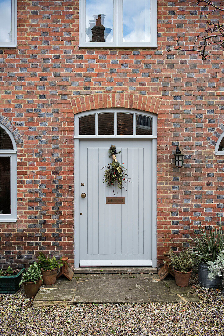 Hellgraue Haustür und Mauerwerk eines Kutschenhauses in East Sussex, England, Vereinigtes Königreich