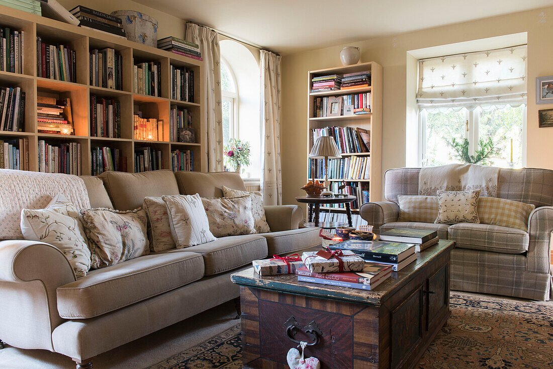 Bücherregale und Sofas in einem Kutschenhaus in East Sussex, England, Vereinigtes Königreich