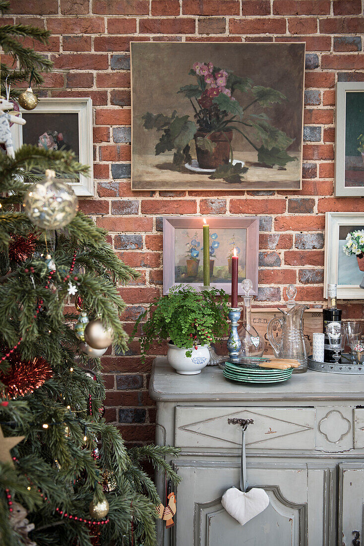 Artwork and sideboard with Christmas tree in East Sussex coach house  England  UK
