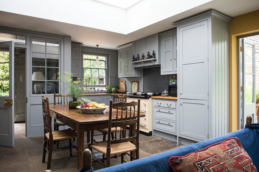 Holztisch und -stühle in hellblauer Einbauküche eines Hauses in Surrey, England, 18