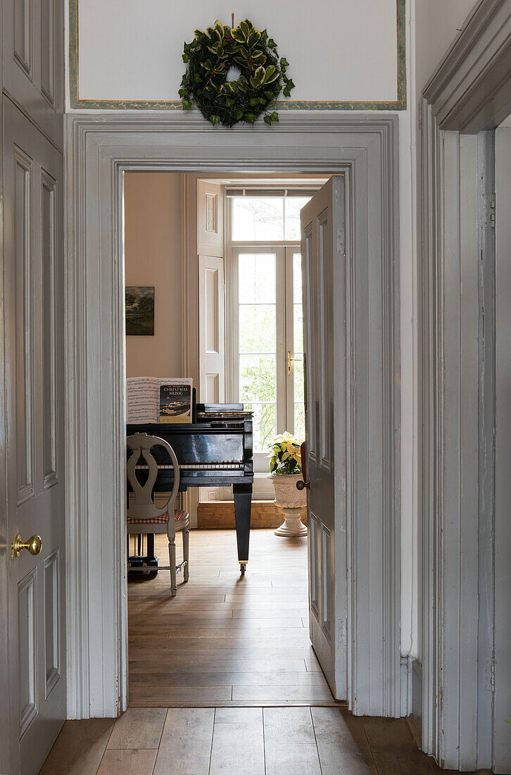 View through white doorframe to grand piano in North London Victorian house  England  UK