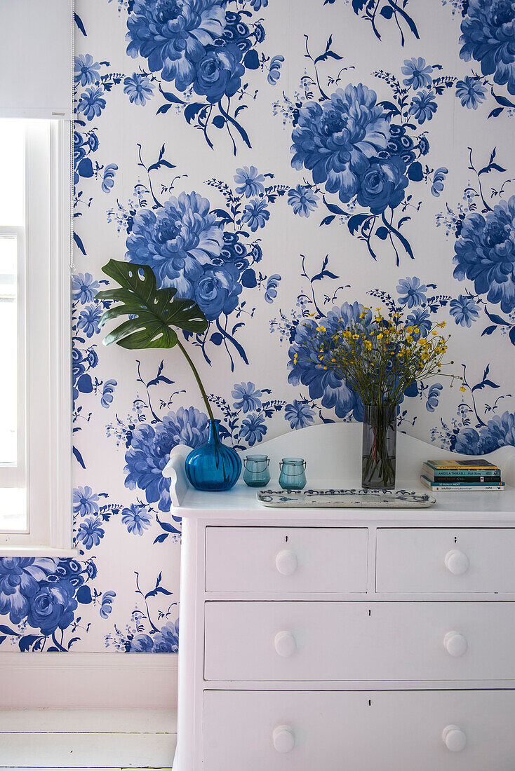 Blue and white floral wallpaper behind chest in in bedroom of Whitstable home   Kent  England  UK