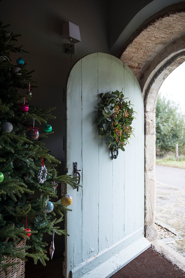Weihnachtsbaum an der gewölbten offenen Eingangstür der unter Denkmalschutz stehenden Priory Headcorn Kent UK