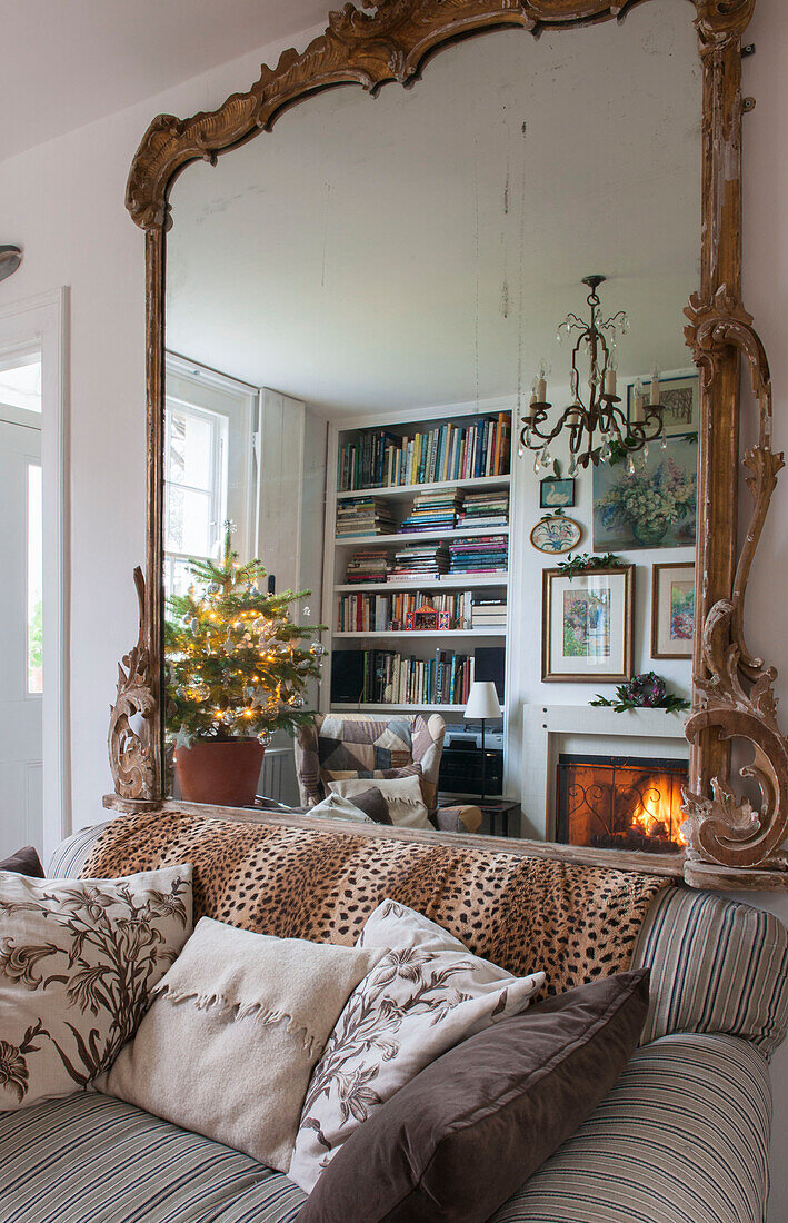 Großer Spiegel über Sofa mit Leopardenmusterüberwurf in Londoner Wohnzimmer England UK