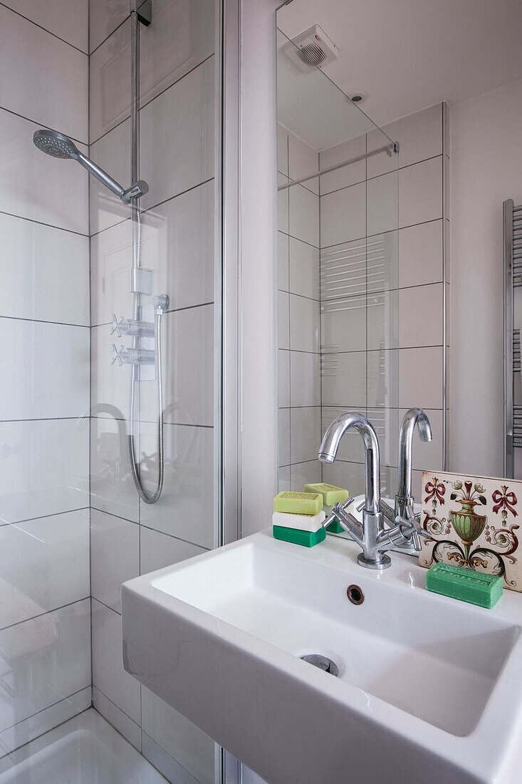 Mischbatterie am Waschbecken mit Seife und Duschkabine in einem Londoner Haus in England UK
