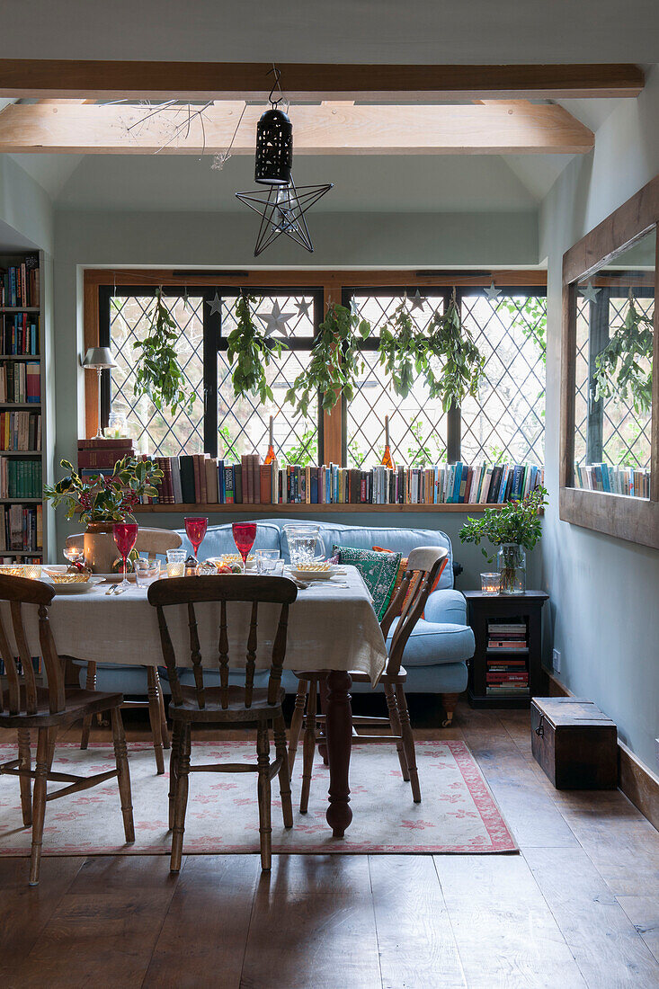 Dining table with books on windowsill in Kilndown cottage  Kent  England  UK