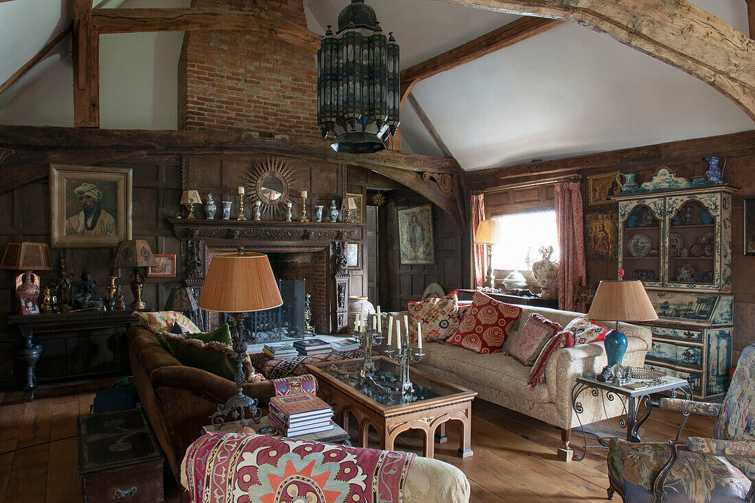 Sofas und Couchtisch mit geschnitztem Holzkamin in einem Haus in Suffolk England UK