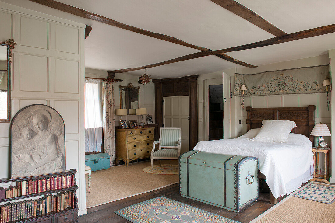 Bestickter Stoff über dem Doppelbett mit Reisekoffer in einem Haus in Suffolk, England UK