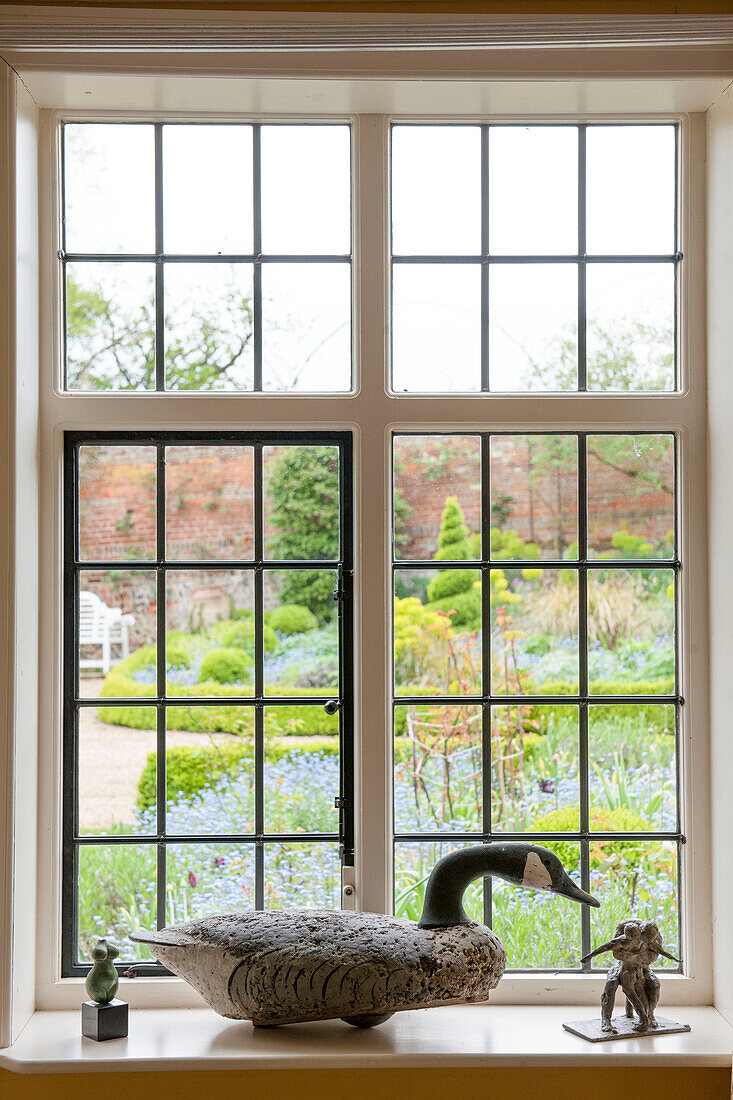 Entenornament auf Bleiglasfensterbank mit Blick auf Garten in Suffolk England UK