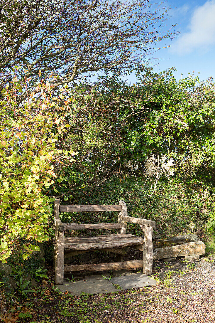 Hölzerne Parkbank im Garten eines Hauses in Devon England UK