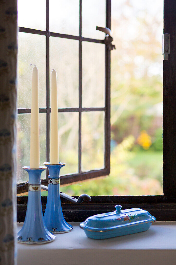 Blaue Kerzenständer und Schale auf der Fensterbank von Amberley cottage West Sussex UK