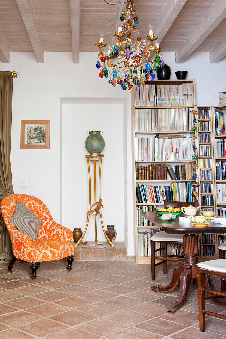 Orange flock armchair with bookcase and chandelier in Castro Marim home, Portugal